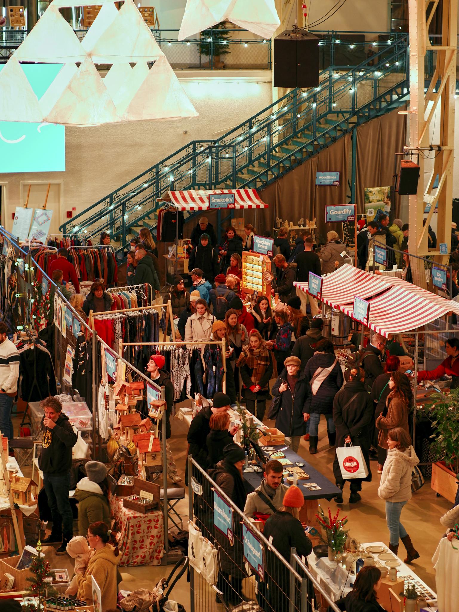 Explore the lively Christmas market atmosphere in Bratislava with people shopping and enjoying the festive stalls.