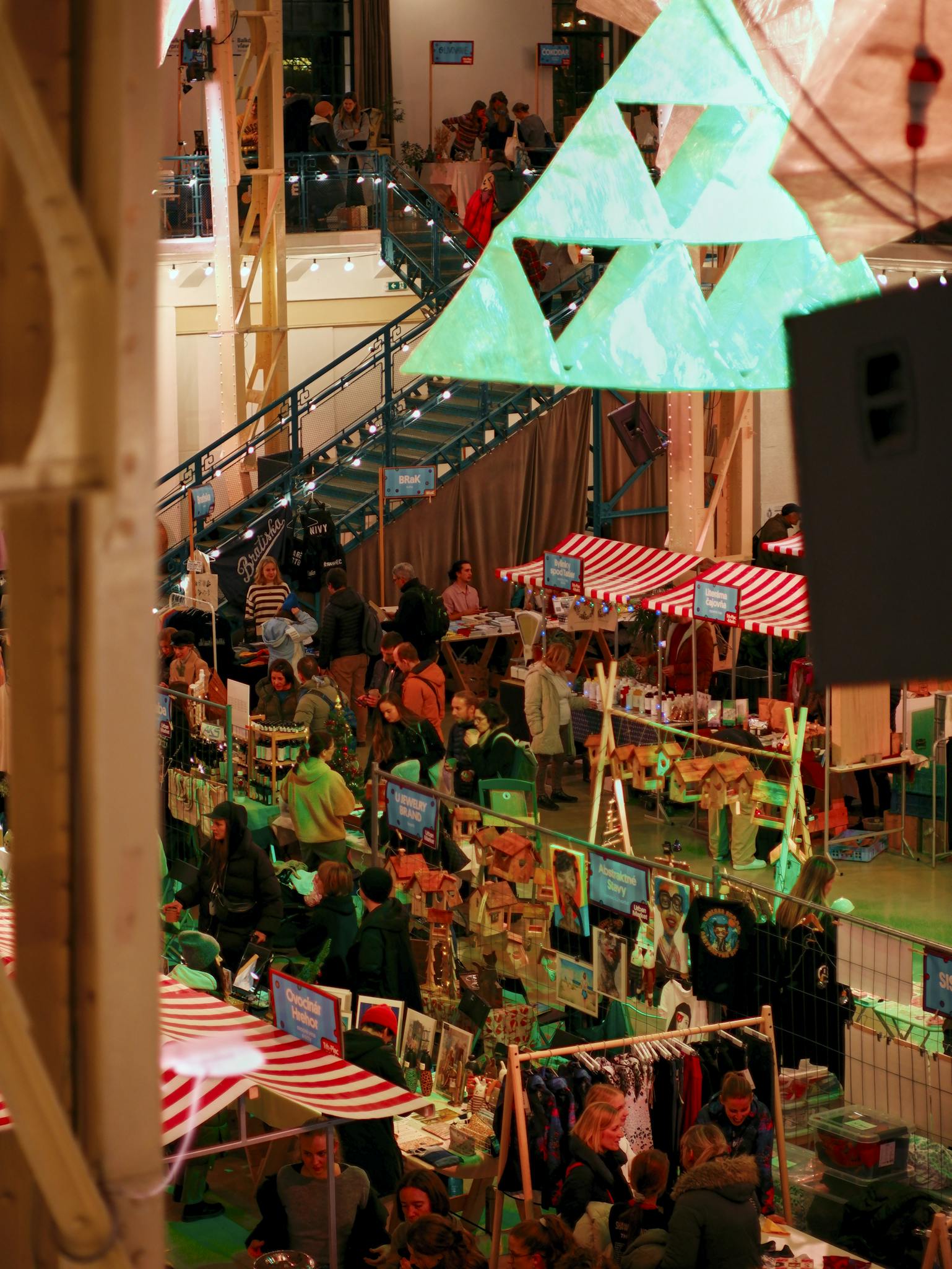Vibrant Christmas market scene in Bratislava with decorations and shoppers enjoying holiday festivities.